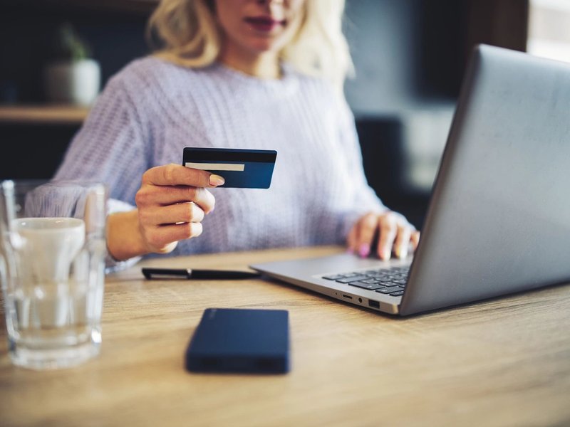 person using laptop to pay online with credit card - Floor Fashions of Virginia in the Charlottesville, VA area